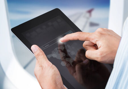 Male hands touching digital tablet with search engine in airplane, Social network concept