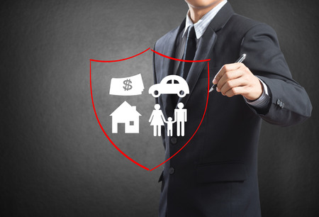 Business man drawing shield protecting family, house, car money   insurance conceptの写真素材