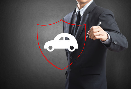 Business man drawing shield protecting auto car, insurance conceptの写真素材