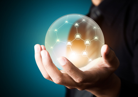 Business people holding social network in crystal ballの写真素材