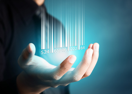 Barcode dropping on businessman hand, financial conceptの写真素材