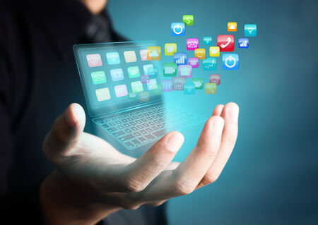Touch screen laptop with colorful application icons in businessman handの写真素材