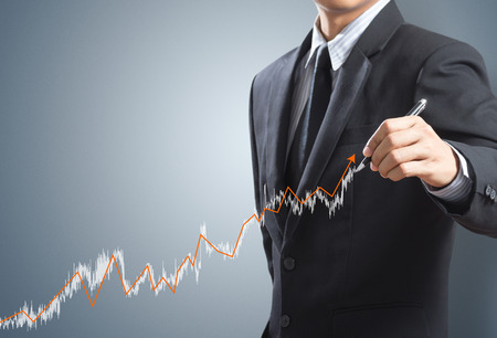 Business man drawing a growing graph conceptの写真素材