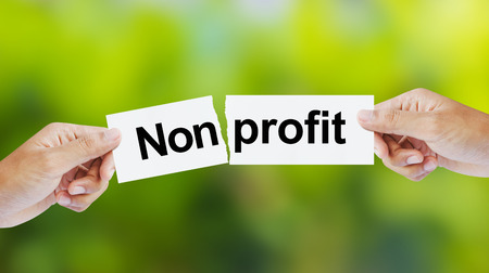 Businessman tearing the word Nonprofit for Profitの写真素材