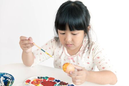 Asian child painting on Easter eggの写真素材
