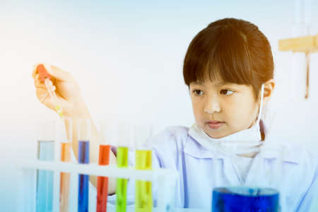 Asian child playing scientist with colorful lab tubesの写真素材