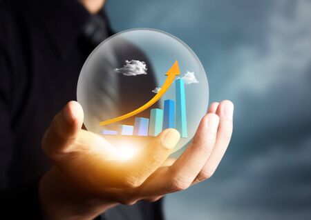 businessman holding increasing graph in crystal ballの写真素材