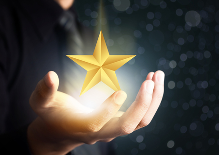 businessman holding excellence starの写真素材
