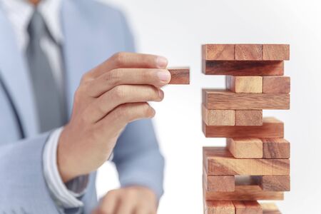 businessman building tower of wooden blocksの写真素材
