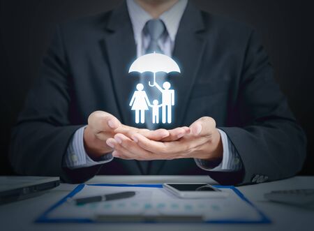 Businessman present family and health insurance concept with umbrellaの写真素材