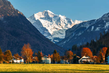 snowy mountain peak with village in autumn and spring, Europe travel destinationの写真素材