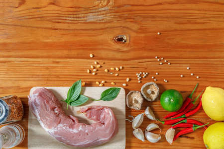 food ingredients on wooden table in kitchen, spaghetti,tomato,garlic,mushroom,line,lemon, chilli, pepper, meat, mint leafの写真素材