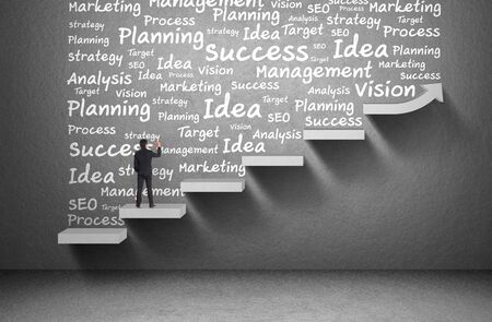 businessman write business word on wall with rising graphの写真素材