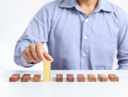 businessman and outstanding wooden toy block, different conceptの写真素材