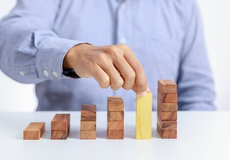 businessman and outstanding wooden toy block, different conceptの写真素材