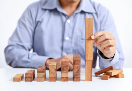 businessman and outstanding wooden toy block, different conceptの写真素材