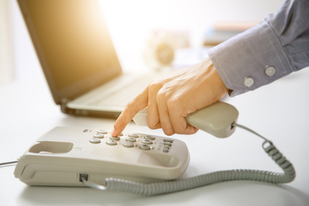 businessman dial digital telephone with office backgroundbusinessman dial digital telephone with office backgroundの写真素材