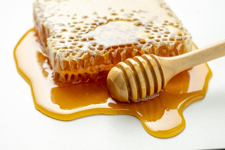 honey and honey comb with wooden stickの写真素材