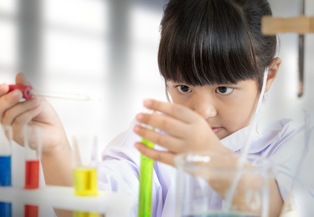Asian child playing scientist with colorful lab tubesの写真素材