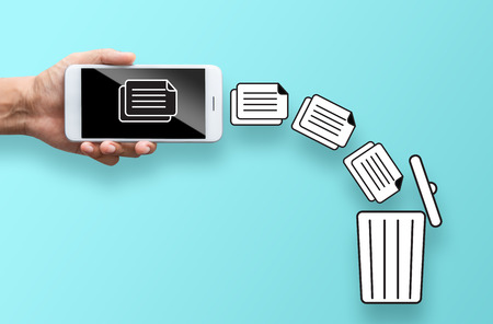 business hand throw data file from mobile to trash binの写真素材