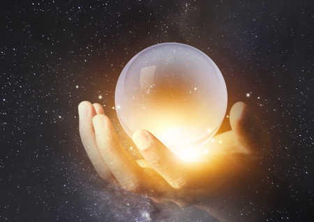 Businessman hand holding crystal clear ball with galaxy universe spaceの写真素材