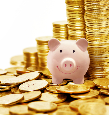 Pink piggy ceramic bank with many golden coins, money savingの写真素材
