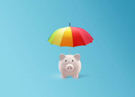Pink piggy ceramic bank with colorful rainbow umbrellaの写真素材