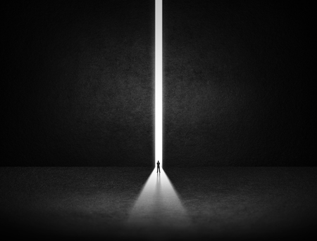 Businessman stand at the exit way with light in the darknessの写真素材