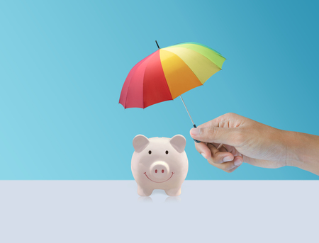 Pink piggy ceramic bank with colorful rainbow umbrellaの写真素材