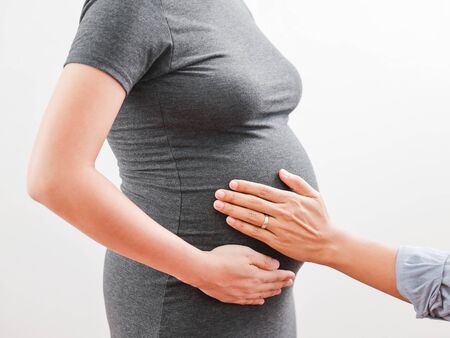 Pregnant woman wife and husband hug with loveの写真素材