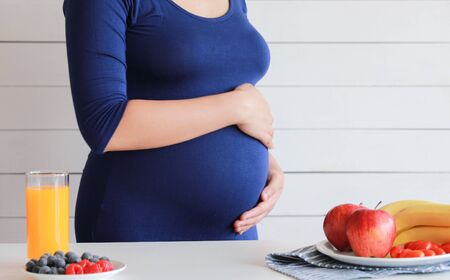 Pregnant woman drink orange juice and fruit, healthyの写真素材