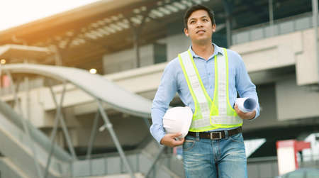 engineer hold blueprint draft paper at construction siteの写真素材