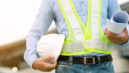engineer hold blueprint draft paper at construction site