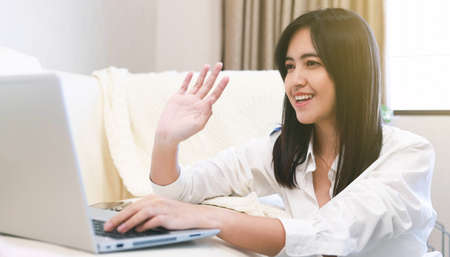 Asian woman use notebook computer laptop for video conference call at homeの写真素材
