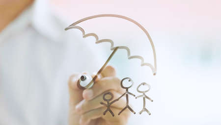 businessman drawing family icon and house for home and health insurance conceptの写真素材