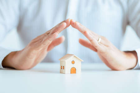 home protection with insurance concept with wooden home model and wooden blocksの写真素材