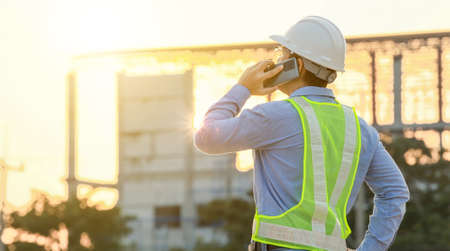 Engineer talk on mobile phone at construction siteの写真素材