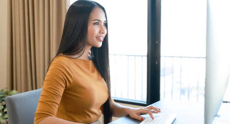 Asian woman use computer to work at office deskの写真素材