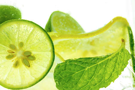 Lemon and line drop in fizzy sparkling water, juice refreshmentの写真素材
