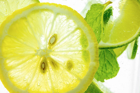 Lemon and line drop in fizzy sparkling water, juice refreshmentの写真素材