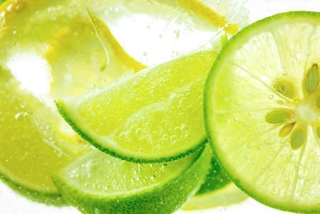 Lemon and line drop in fizzy sparkling water, juice refreshmentの写真素材