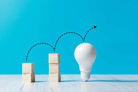 wooden cubes with light bulb, rising business growth graph chartの写真素材