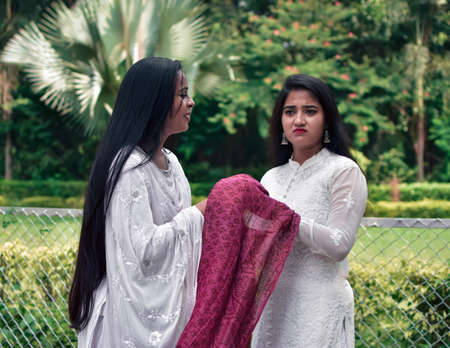 Portrait of two Asian women wearing traditional clothes in the garden.