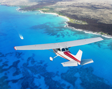 plane flying above blue ocean