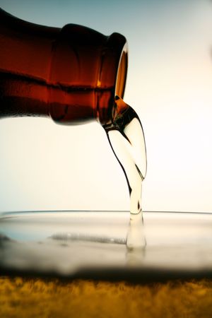 pouring some cold beer to the glassの写真素材