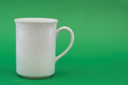 image of a white coffee cup placed infront of a green backdropの写真素材