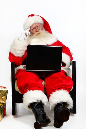 father christmas using laptop and thinkingの写真素材