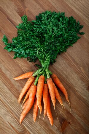bunch of organic carrots placed on wooden surfaceの写真素材