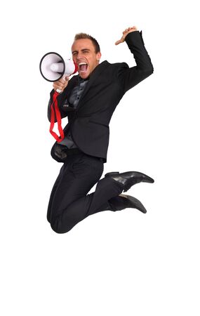 young businessman making announcement with a megaphone as he jumpsの写真素材