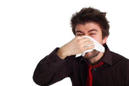 young man with cold virus blowing his noseの写真素材